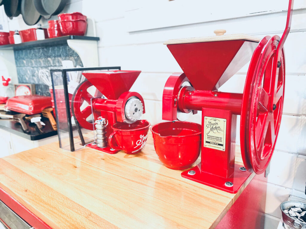 Two GrainMaker mills on a wooden counter.