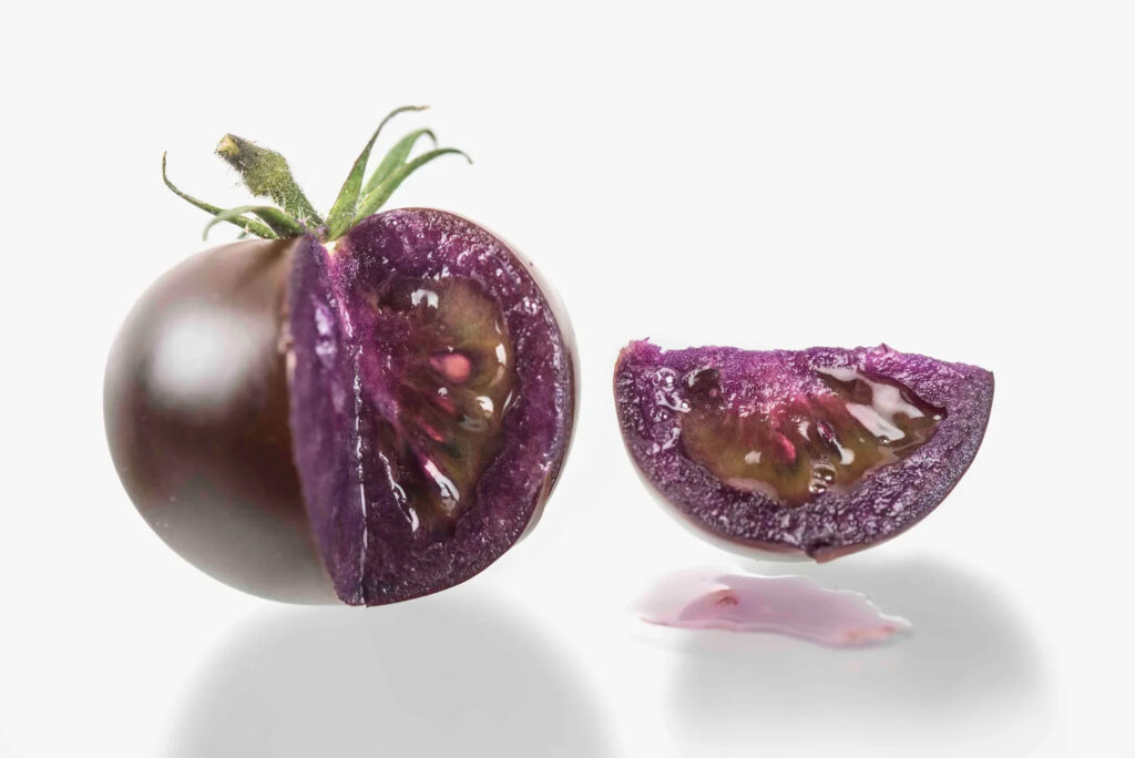 A GMO purple tomato with a slice taken out.