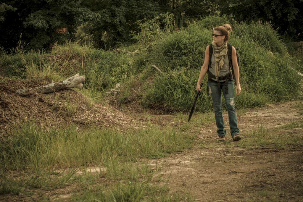A woman walking on a trail with a bug out bag on.
