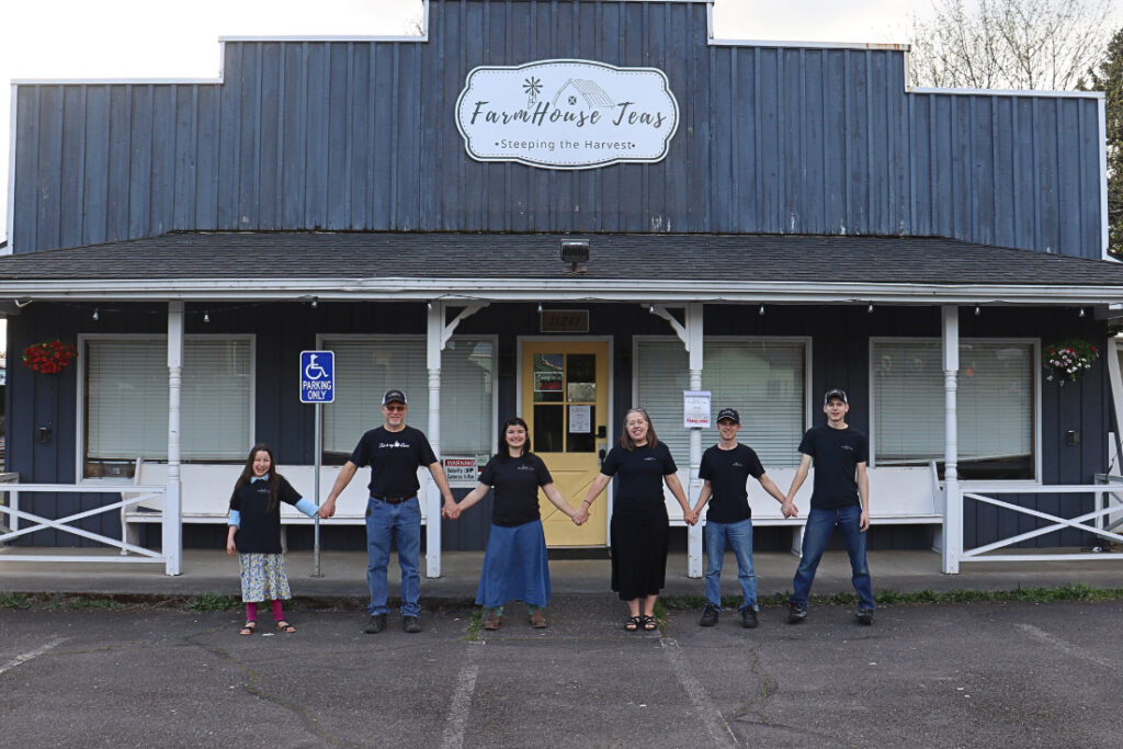 A family standing in front of Farmhouse Teas.