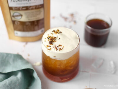 A glass of homemade herbal soda with cream on top.