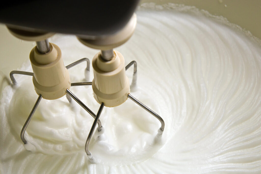 Making homemade whipped cream in a stand mixer with whipping attachments. 