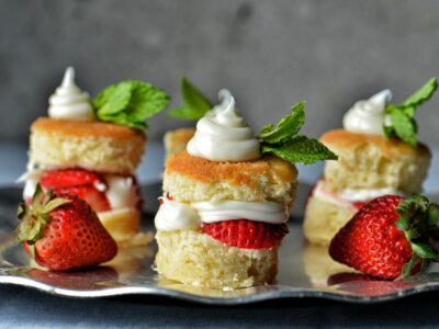 Stacks of homemade strawberry shortcake on a platter with mint and fresh strawberries