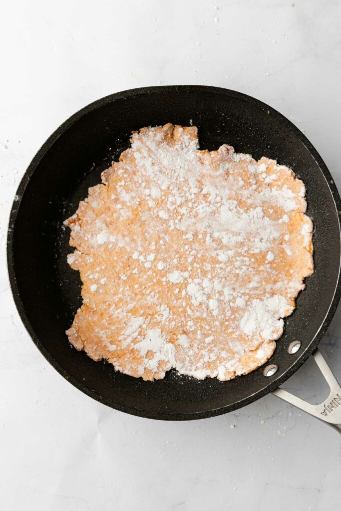 A sweet potato tortilla cooking in a pan.