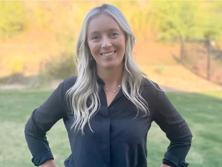 A woman in a black shirt with blonde hair.