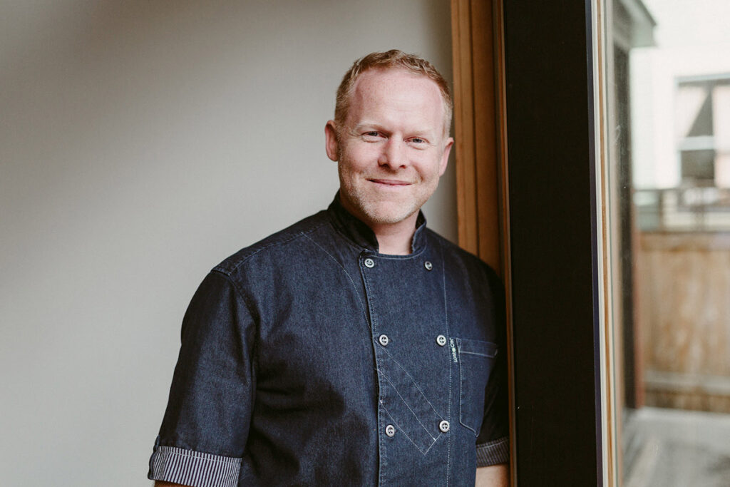 A chef leaning against a window.