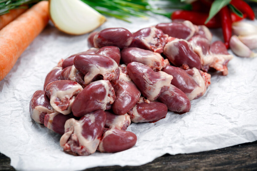 Chicken hearts and gizzards in a white bowl.