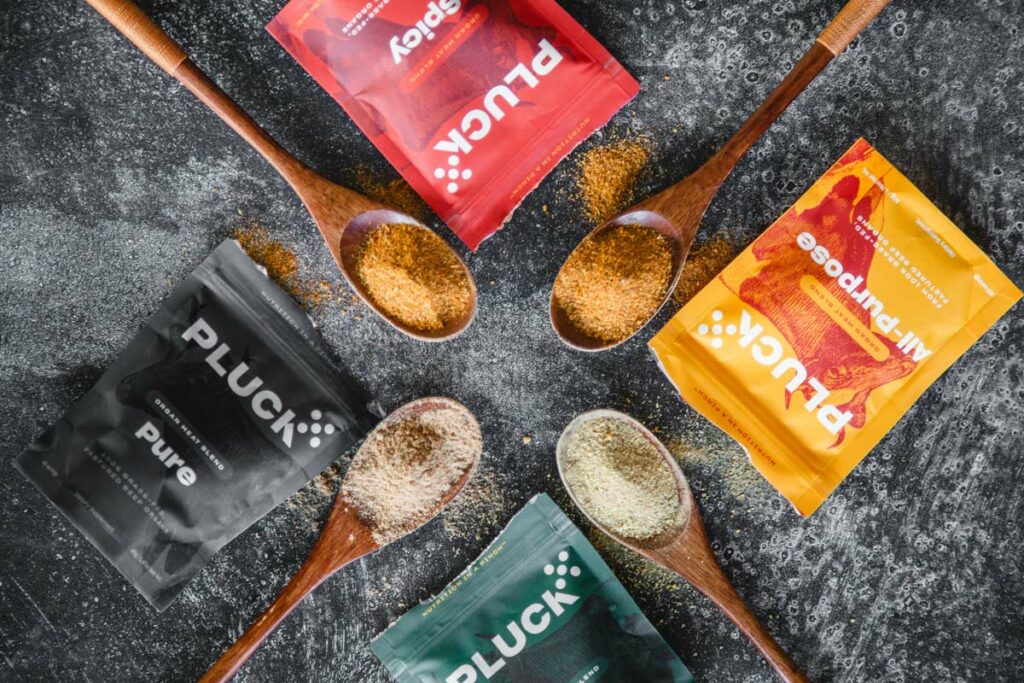 Four Pluck Seasoning flavors on wooden spoons.