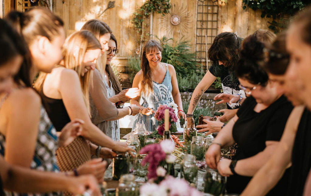 A woman hosting an event with people making fermented foods.