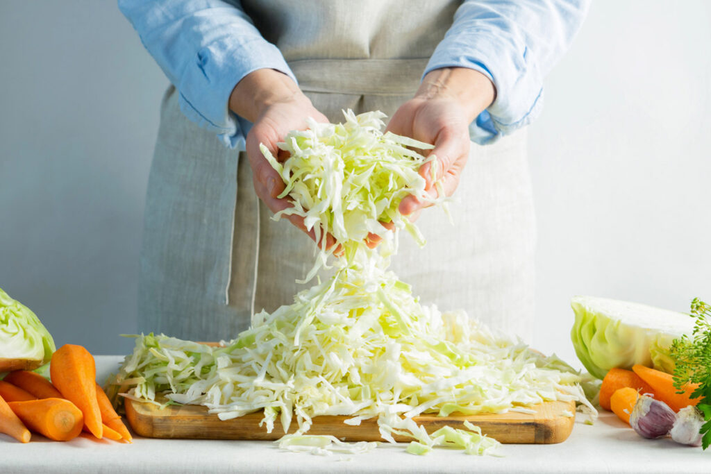 A woman slicing cabbage to make sauerkraut.