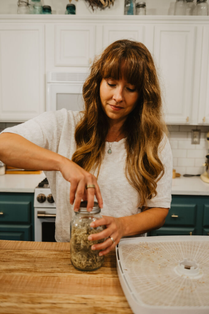 A woman screwing a lid onto a Mason jar.