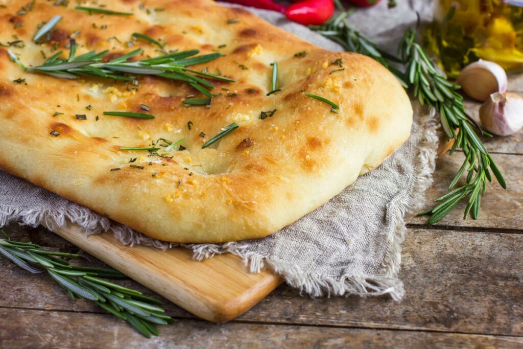 Herb focaccia bread on a cutting board.