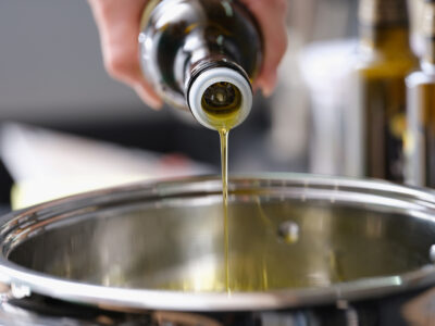 Olive oil being poured into a saucepan.