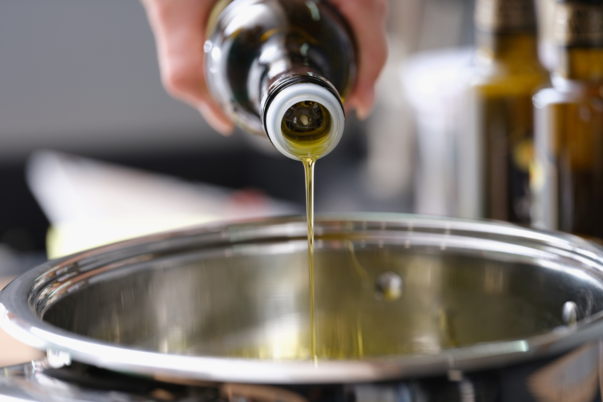 Olive oil being poured into a saucepan.