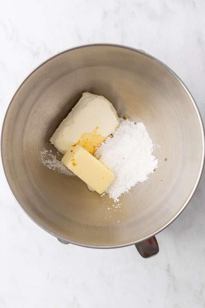 Frosting ingredients in the bowl of a stand mixer.