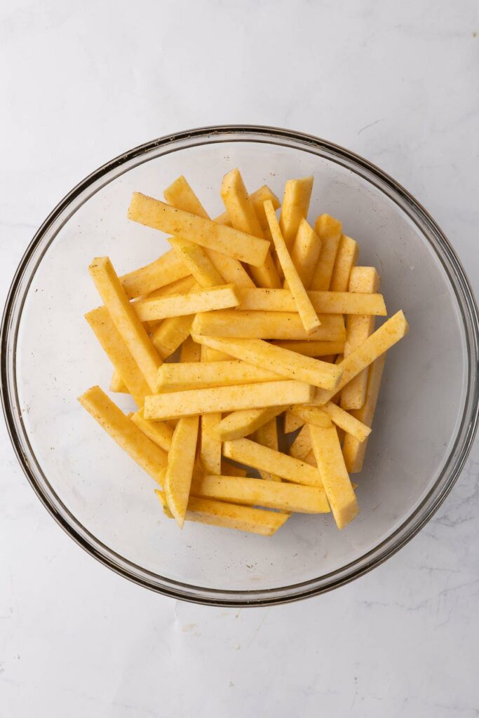 Sliced rutabaga in a glass bowl.