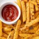 Rutabaga fries on a white plate with dipping sauces.