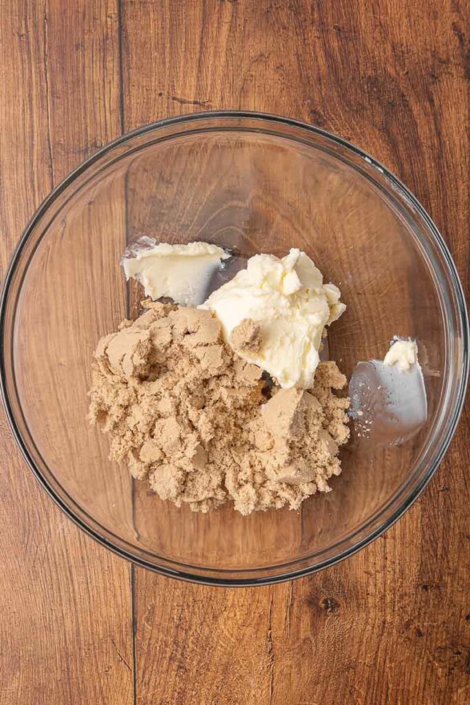 Christmas pudding batter being made in a clear glass bowl.