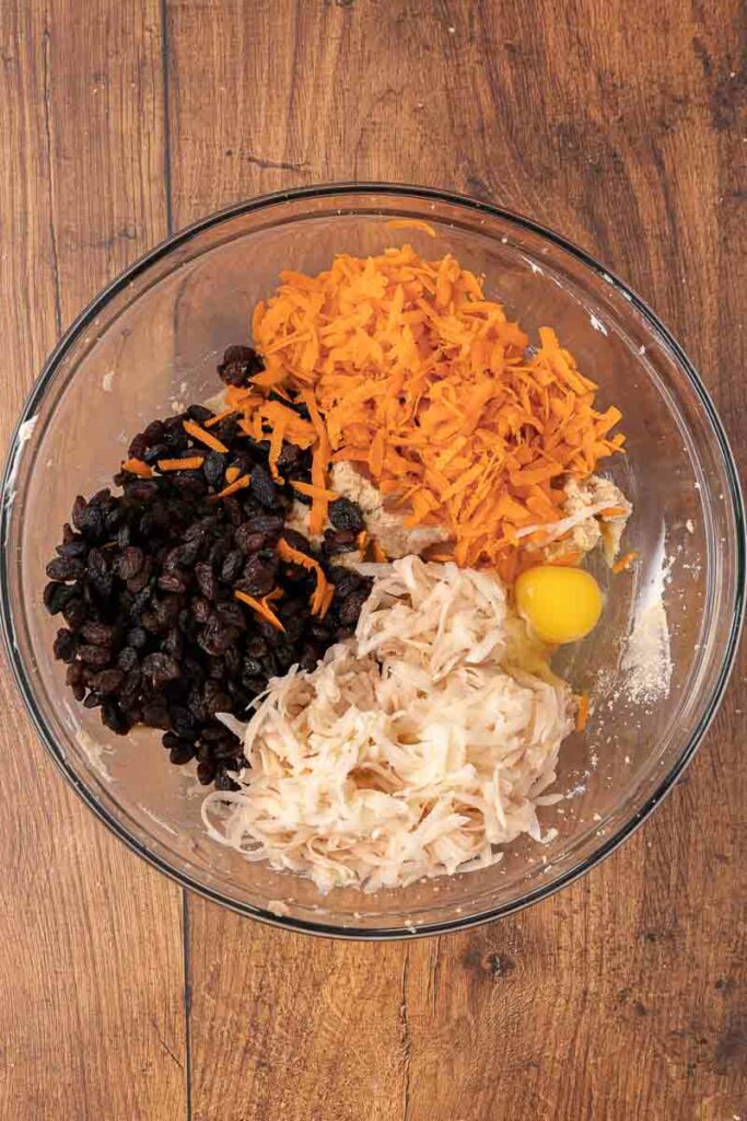 Christmas pudding batter being made in a clear glass bowl.