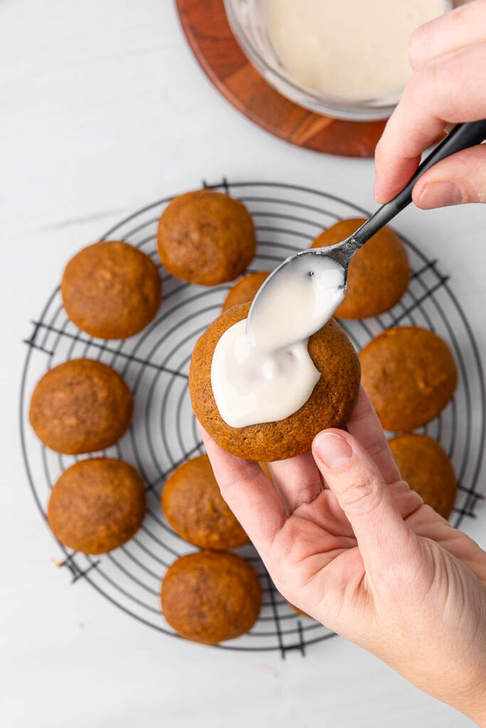 Cookies being iced with frosting.