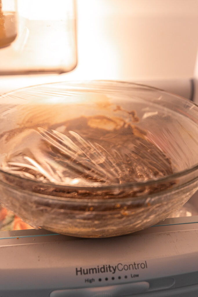 Ginger cream cookie dough in a glass bowl in the refrigerator.