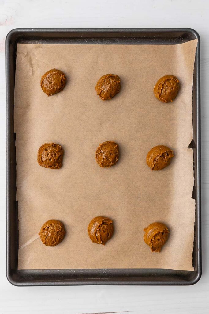 Ginger cream cookie dough on a parchment paper lined cookie sheet.