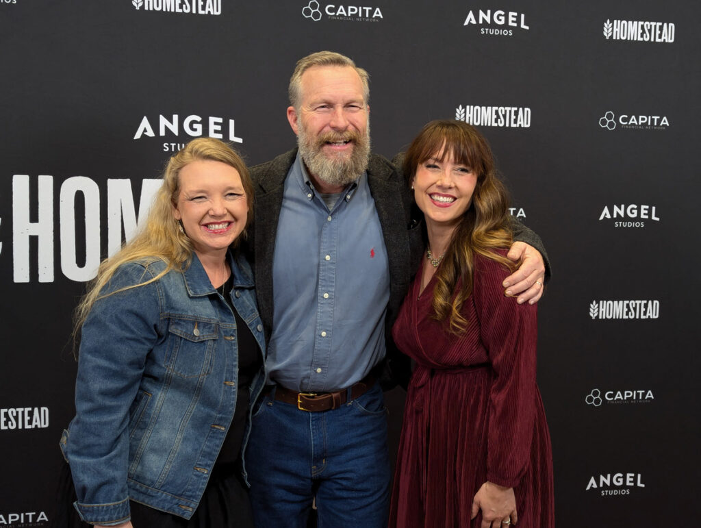 Three people standing on the red carpet.