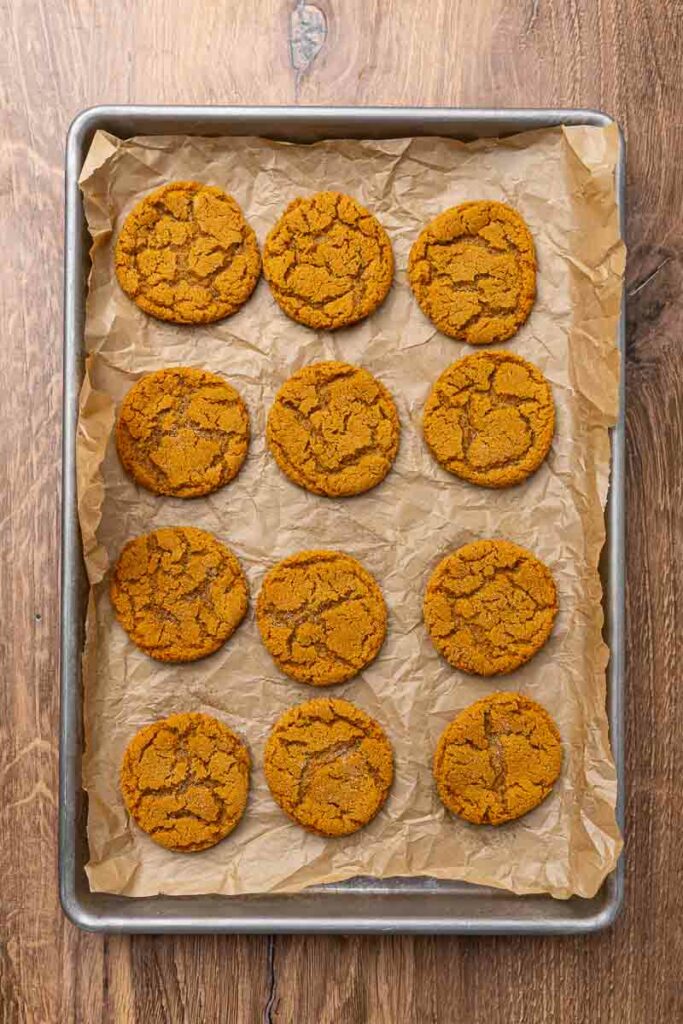 Molasses cookies baked on a cookie sheet.