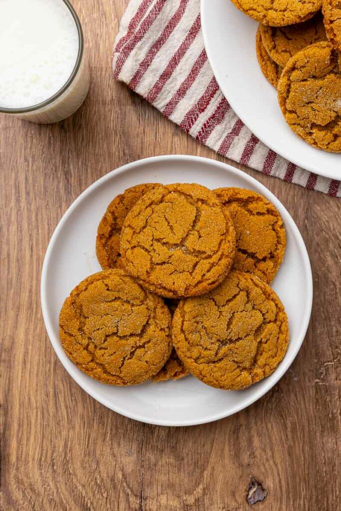 A plate full of molasses cookies with another in the background.