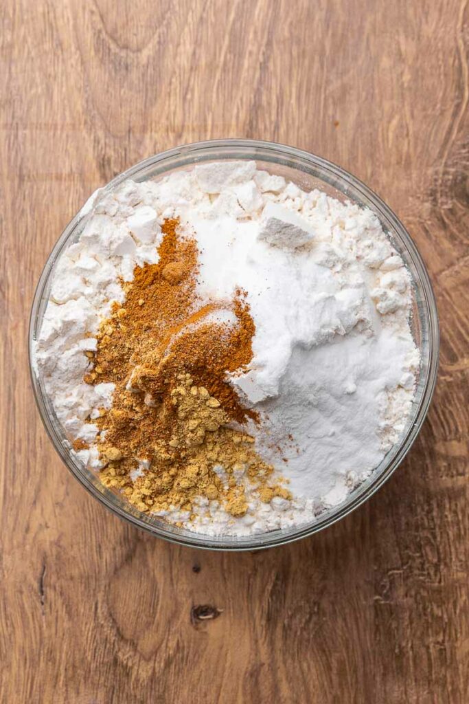 Dry ingredients for molasses cookies in a large bowl.