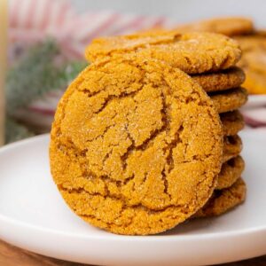 A stack of molasses cookies on a white plate.