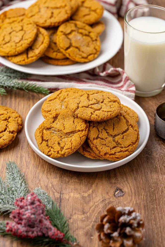 A plate full of molasses cookies with another in the background.