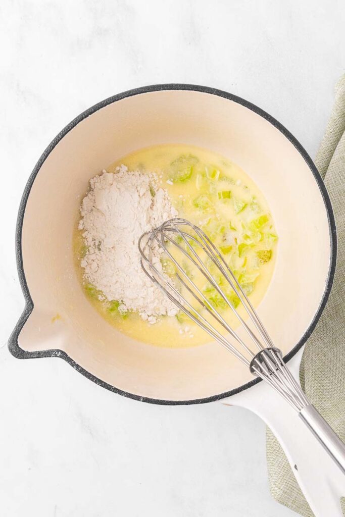 Flour being added to sauteed celery and butter.