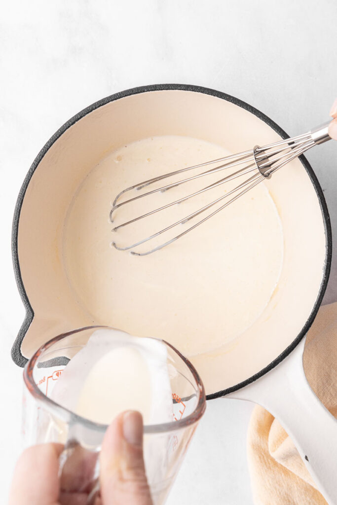 Heavy cream being poured into cream of chicken soup.