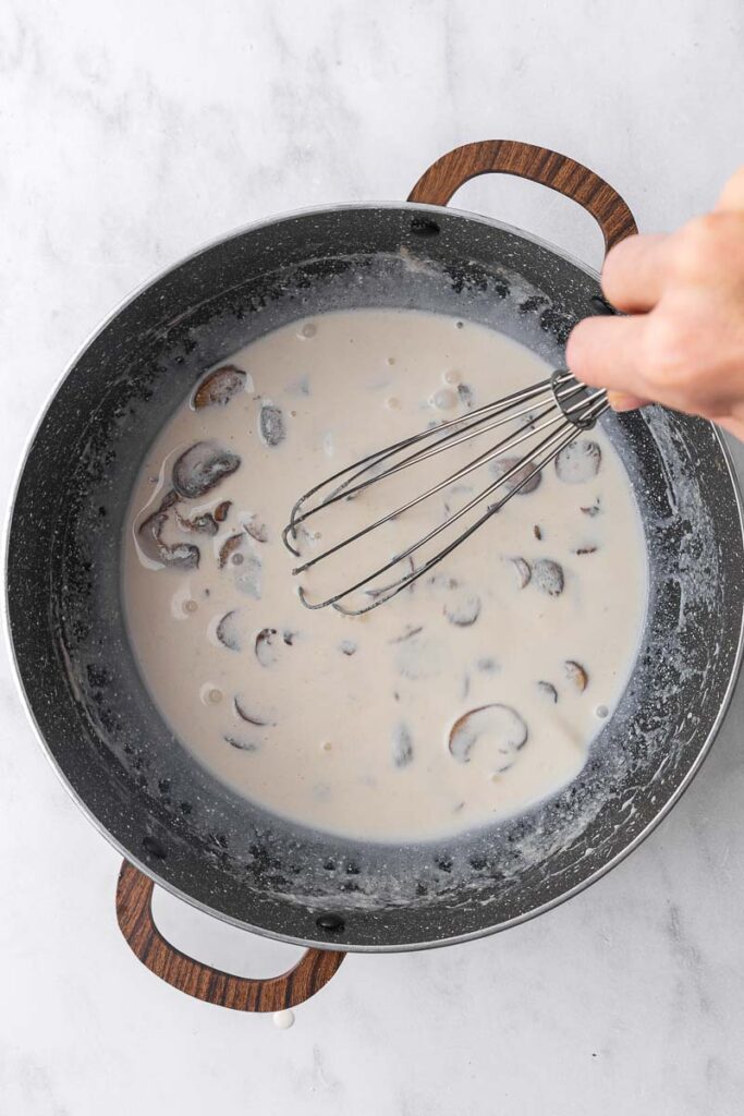 Cream of mushroom soup being whisked.