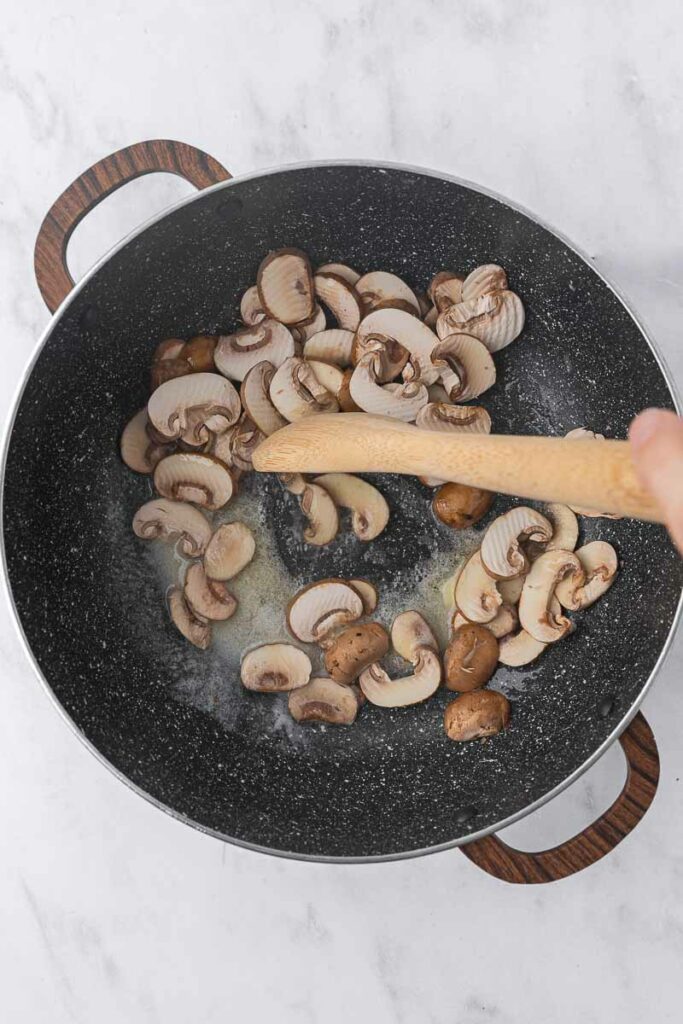 Sliced mushrooms cooking in butter.