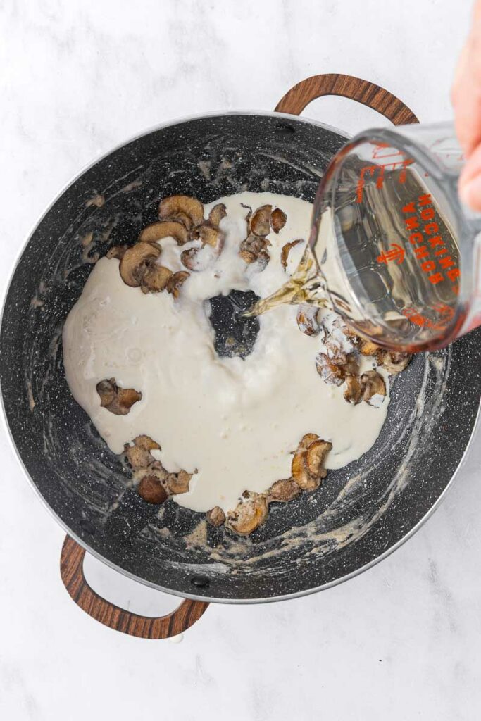 Broth being added to cream of mushroom soup.