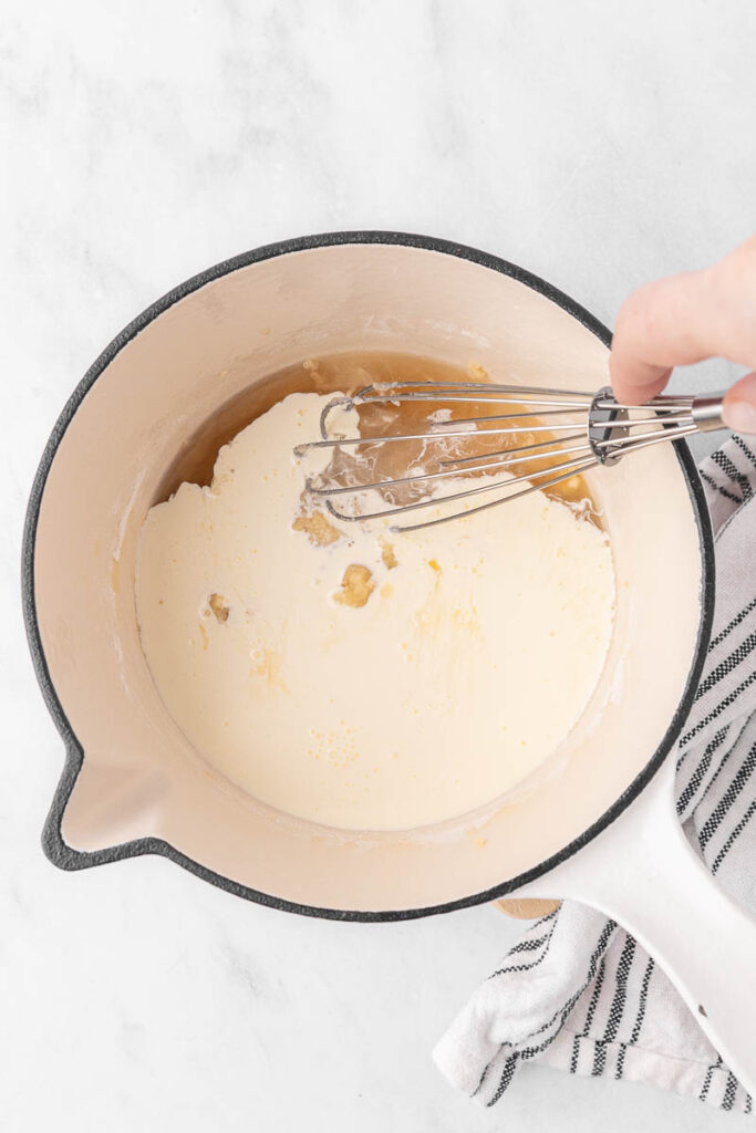 Whisking together milk into the cream of potato soup.