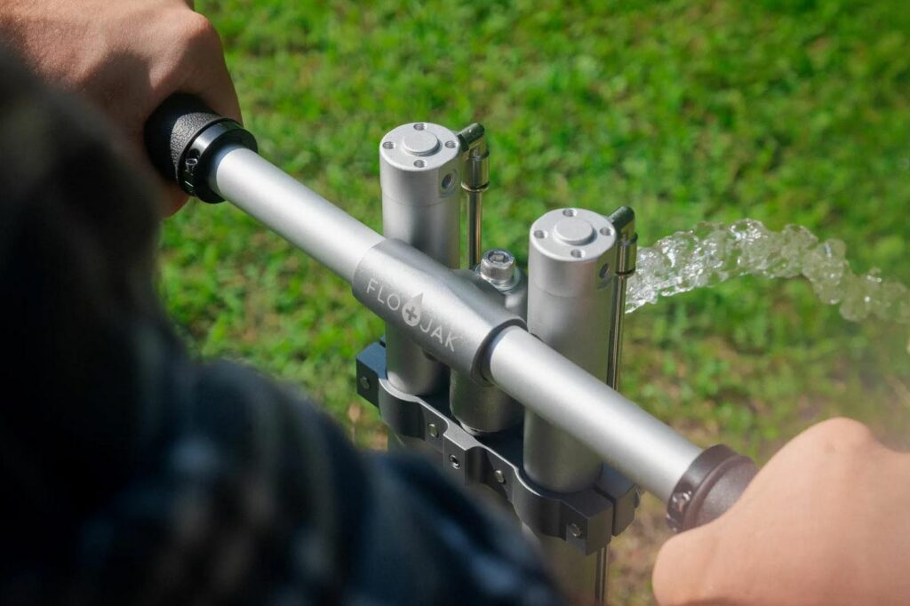 A man hand pumping water from a well.