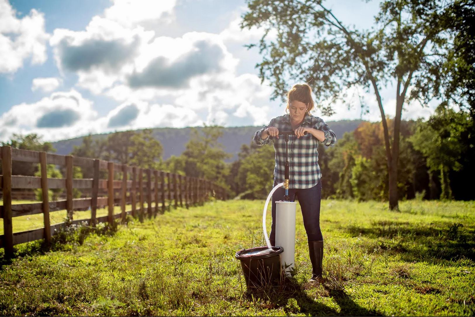 A woman hand pumping water from a well.