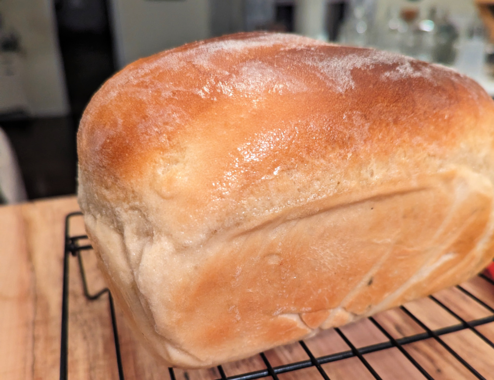 Sourdough sandwich loaf on a wire cooling rack.