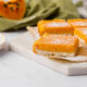 Papaya bars dusted with powdered sugar on a white cutting board.