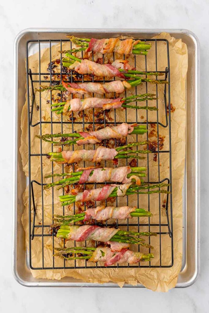 Bacon wrapped asparagus on a wire rack.