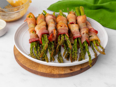 Bacon wrapped asparagus on a white plate.