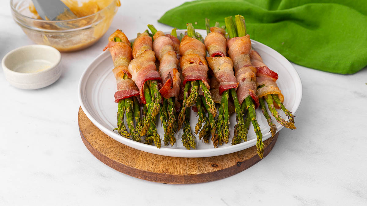 Bacon wrapped asparagus on a white plate.