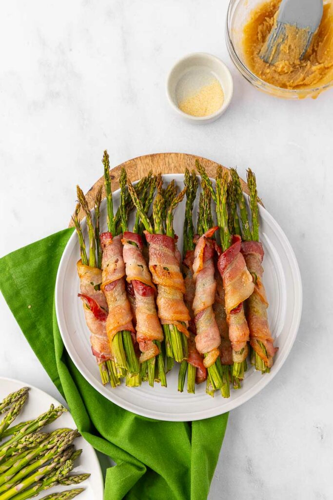 Bacon wrapped asparagus on a white plate.