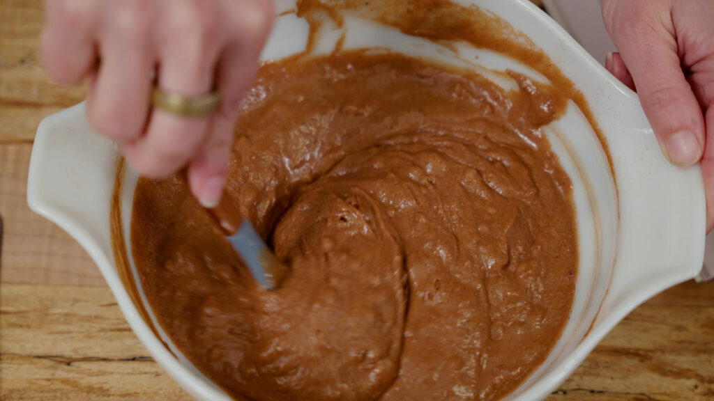 Chocolate wacky cake batter being mixed in a bowl.