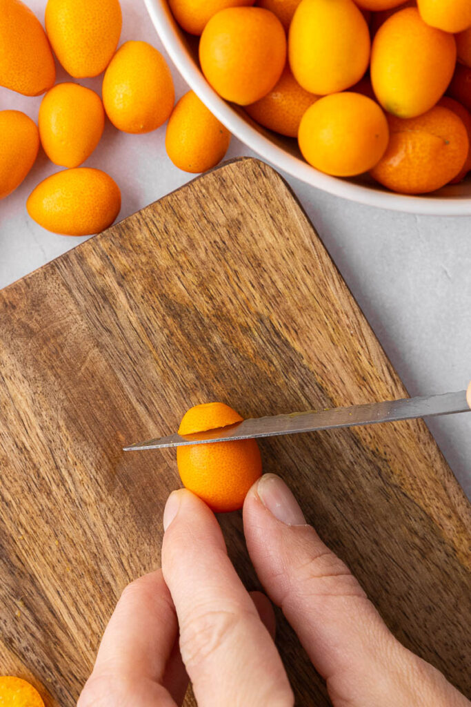 Kumquats being sliced into rounds.