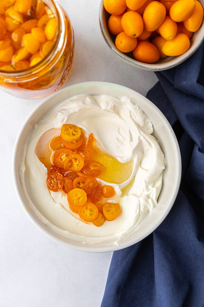 Candied kumquats in a bowl of yogurt.