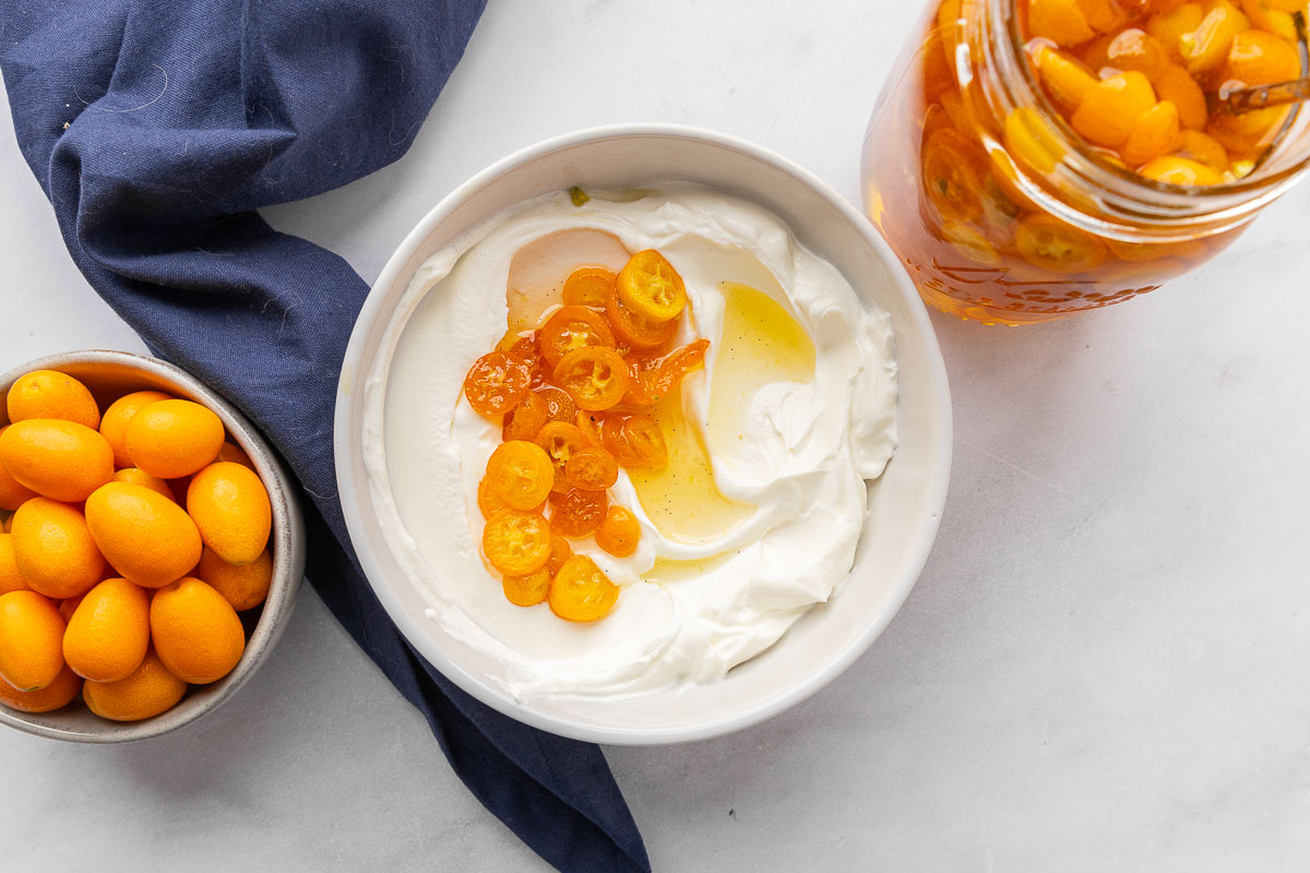 Candied kumquats in a bowl of yogurt.